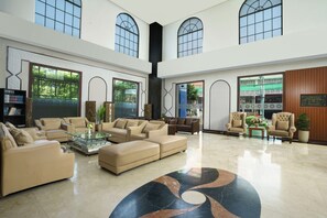 A spacious lobby with high ceilings, large windows, and a central seating area with sofas and a coffee table. - Hotel Namira Syariah Pekalongan (Pekalongan)