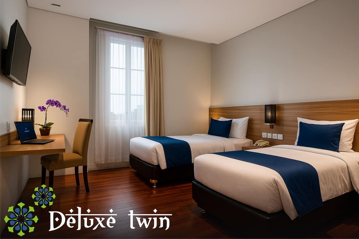 A hotel room with two beds, a desk with a laptop, a TV, and a window with curtains.