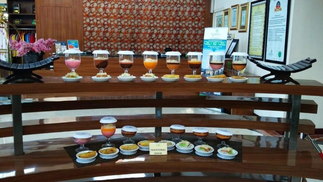 A buffet table with various food and drink options, including desserts and traditional snacks.