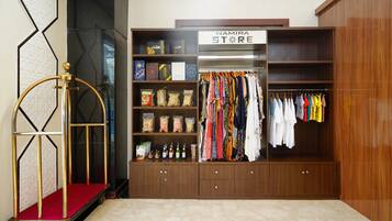A boutique store with a wooden interior, a clothing rack, and shelves stocked with various items.