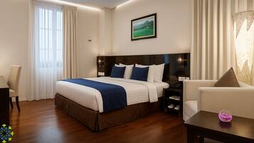 Una habitación de hotel moderna con una cama grande, un escritorio, una silla y un sofá.