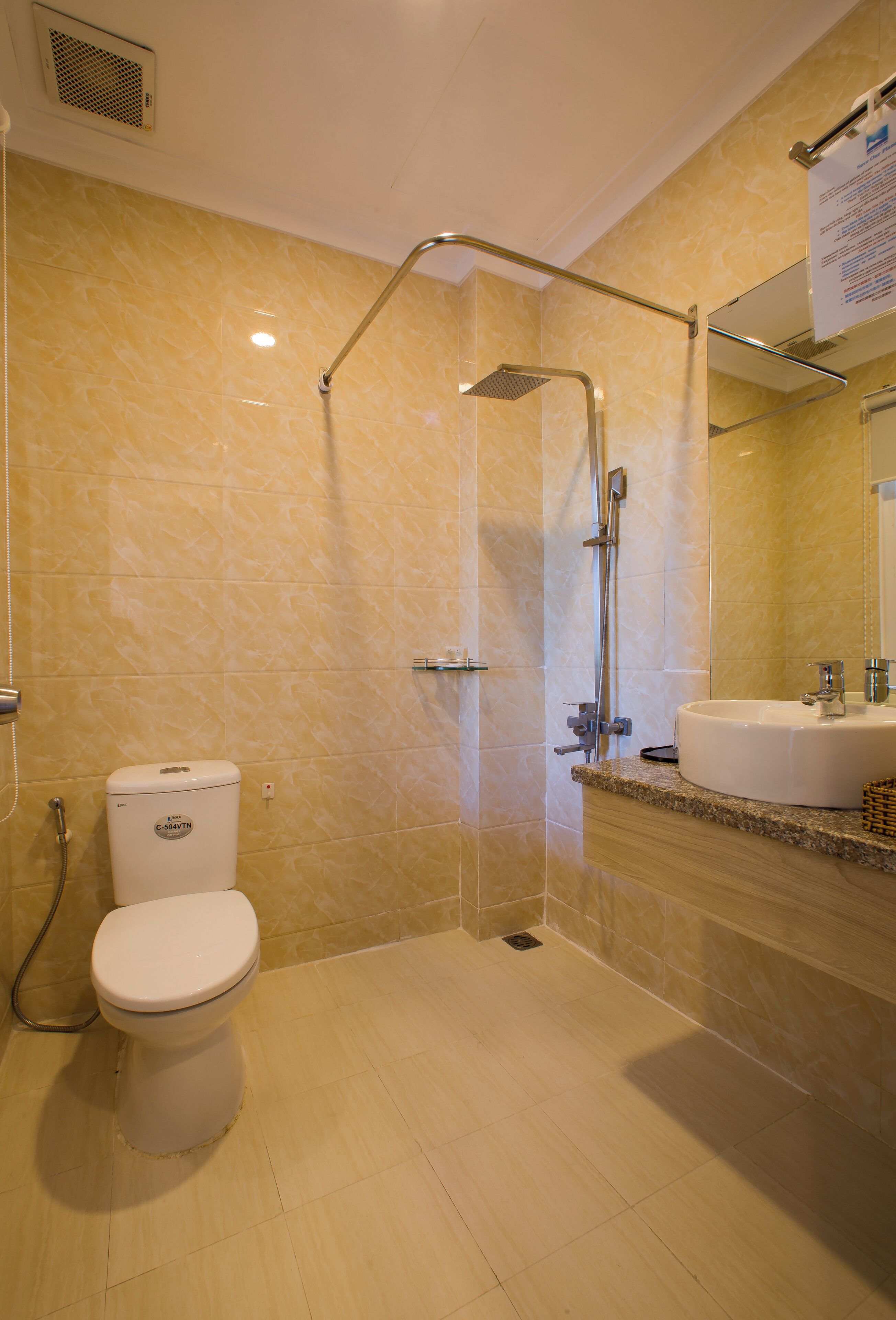 A bathroom with a toilet, a shower, and a sink.