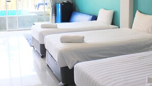 A hotel room with two beds, a large window with curtains, and a view of a pool. - Kata Sea Boutique (Karon)