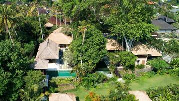 Escape to a serene tropical haven with bungalows surrounded by lush gardens and a central pool.