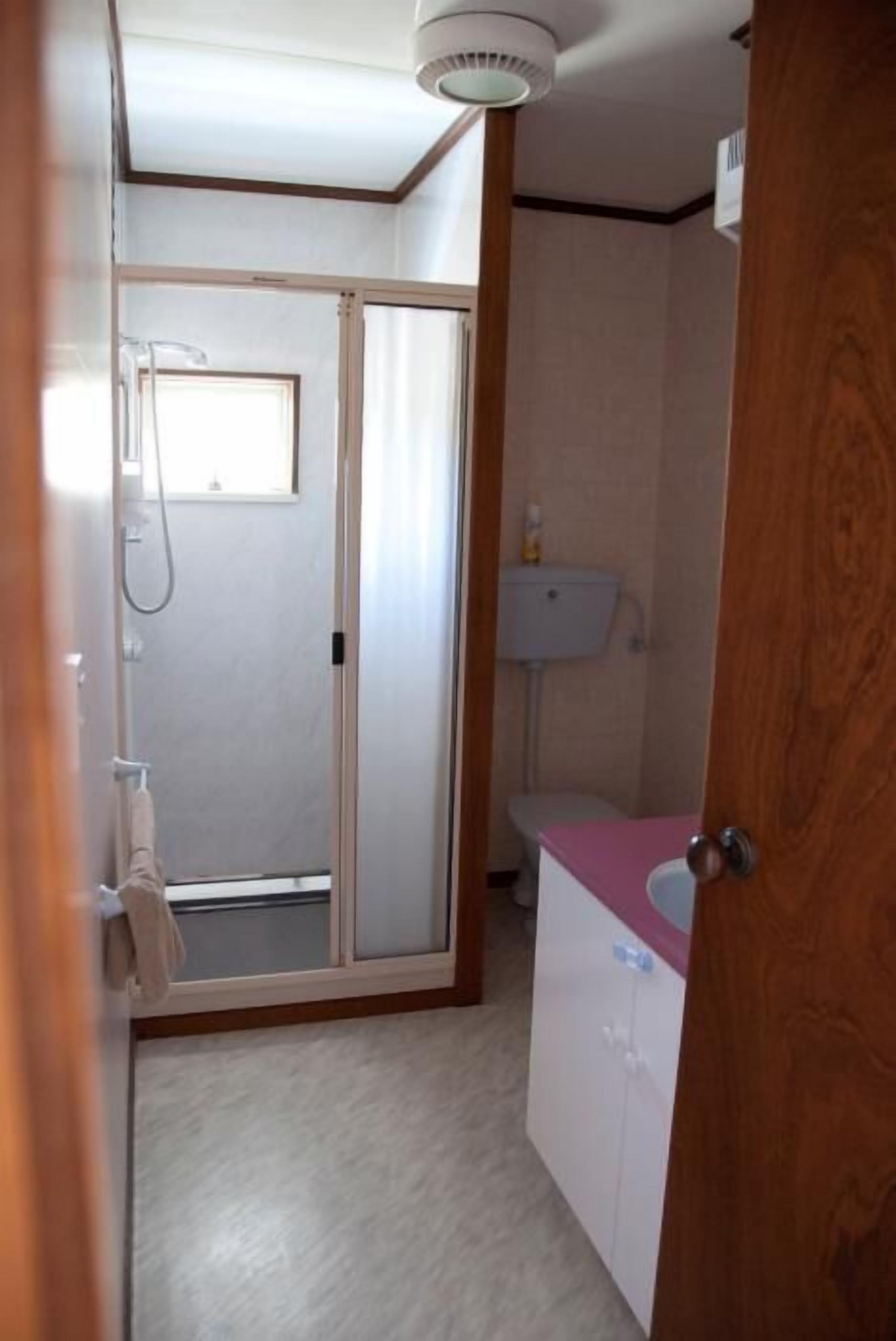 A bathroom with a shower, toilet, and sink.