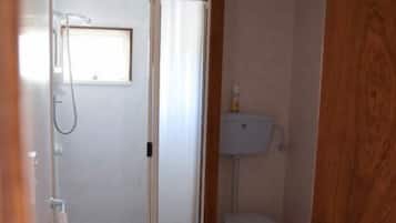 A bathroom with a shower, toilet, and sink.