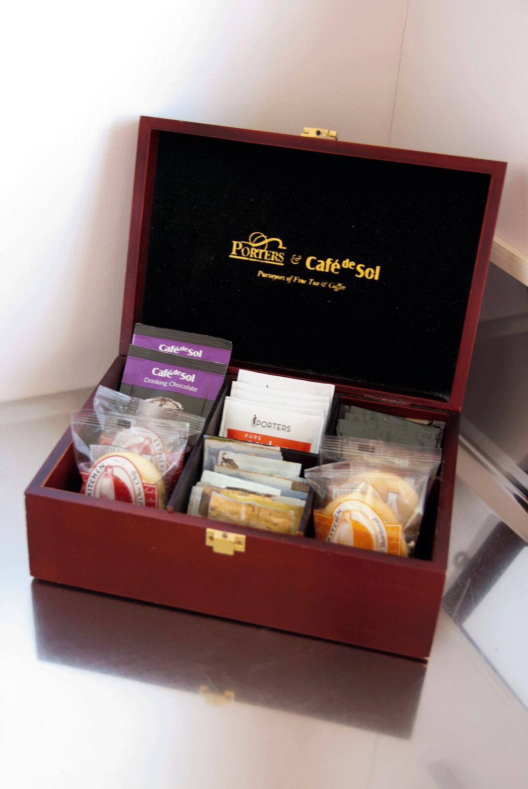 Una caja de regalo con interior negro y el logotipo que dice "Porters & Café de Sol".
