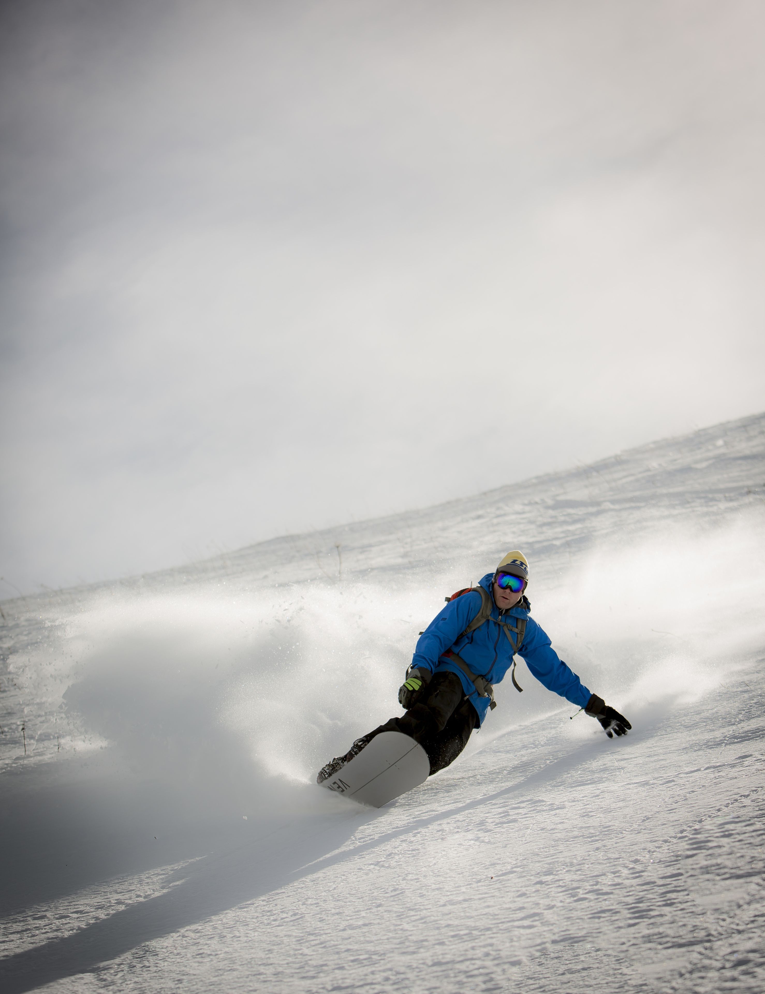 A snowboarder in a blue jacket and helmet.