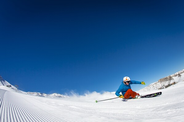 A person skiing down a snow-covered slope.