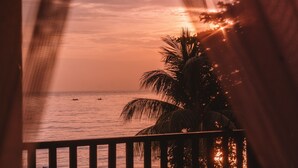 A view of the ocean with palm trees and a railing. - Bondalem Beach Club (Tejakula)