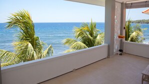 A balcony with a view of the ocean and palm trees. - Bondalem Beach Club (Tejakula)