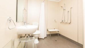 A modern bathroom with a white sink, toilet, and shower.