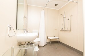 A modern bathroom with a white sink, toilet, and shower.