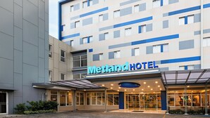 A Metland Hotel with a modern facade, large windows, and a covered entrance area. - Metland Hotel Bekasi (Cikarang)