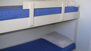 A bunk bed with a blue mattress and white bedding.