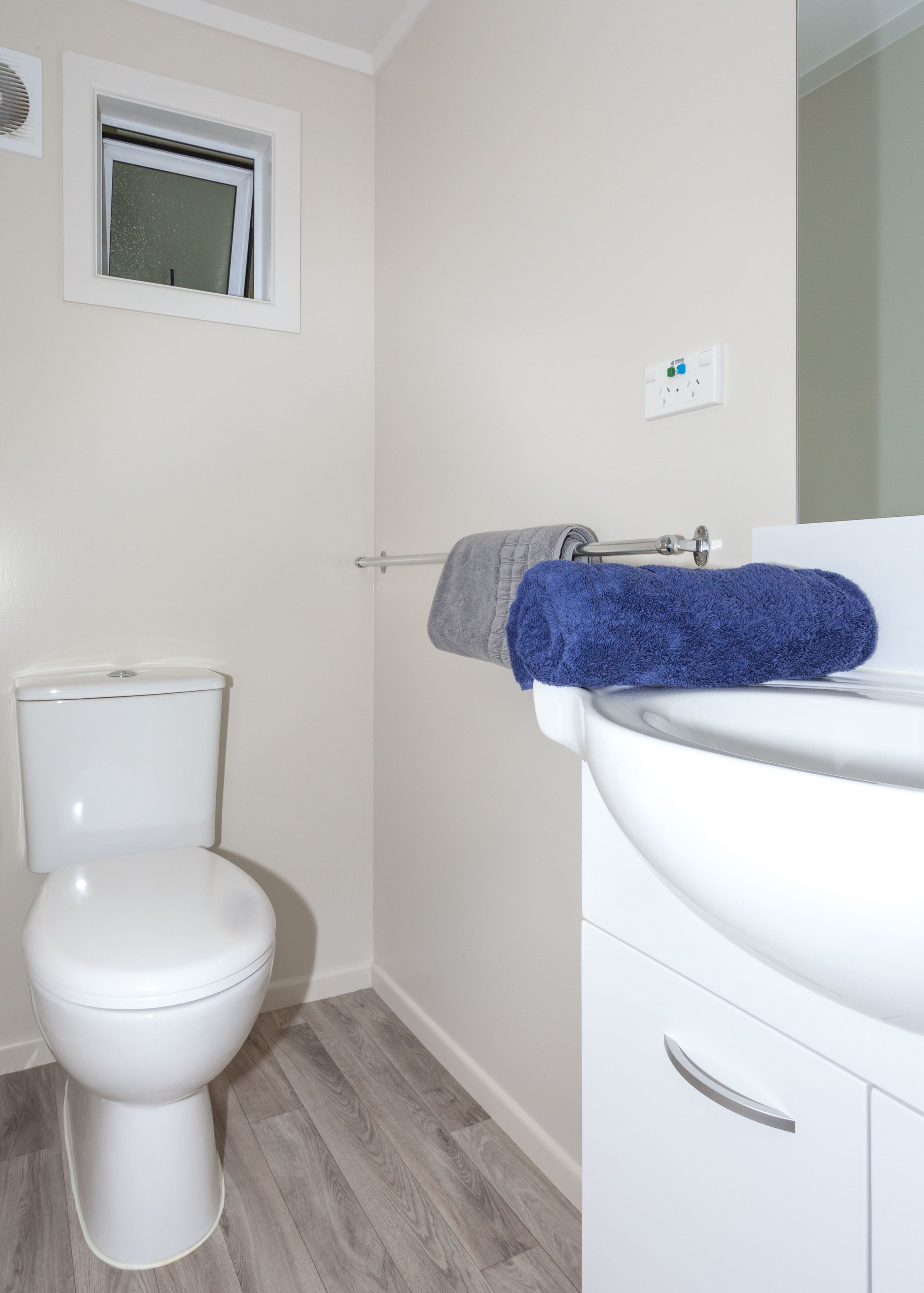 Un baño con inodoro, lavamanos y ventana.