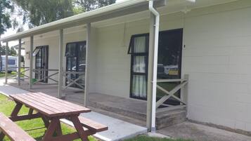 Una fila di cabine a un piano, ciascuna con un portico e un tavolo da picnic in primo piano.