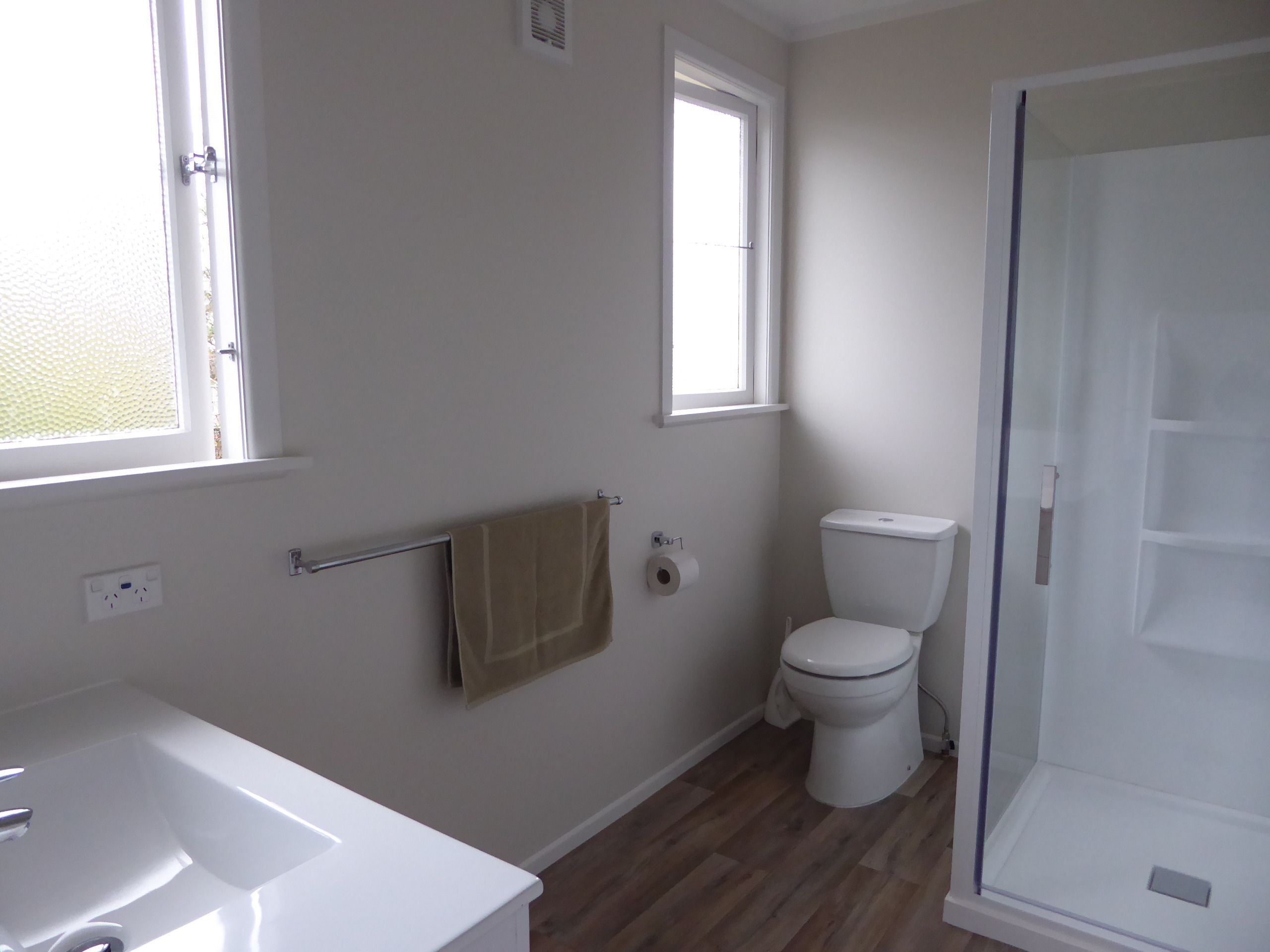 Un baño con una bañera blanca, un inodoro y una cabina de ducha de vidrio.