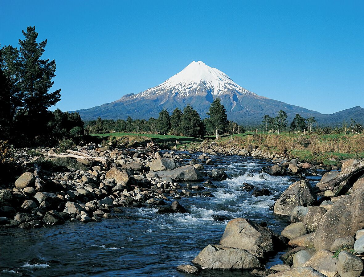 A river with rocks and a mountain in the background.