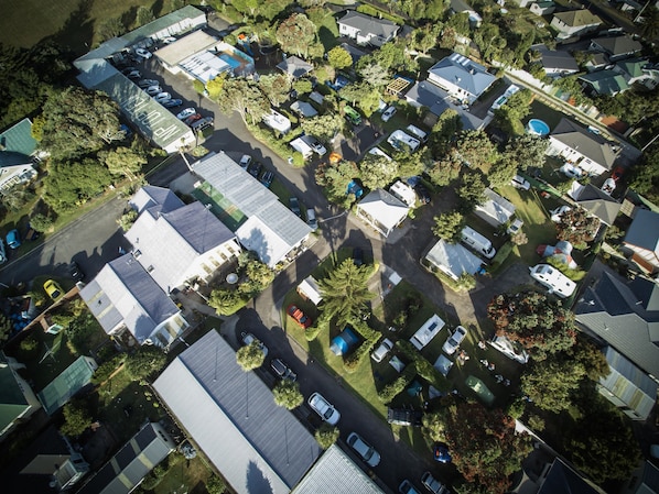 Vista aérea de una zona residencial con varias casas, vehículos recreativos y automóviles.