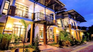 A two-story building with a balcony and a covered walkway.