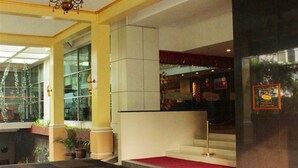 A hotel lobby with a grand chandelier, a red carpet, and a staircase leading to an upper level. - Balairung Hotel (Jakarta)