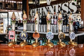 A bar with multiple tap handles, each labeled with different beer names.