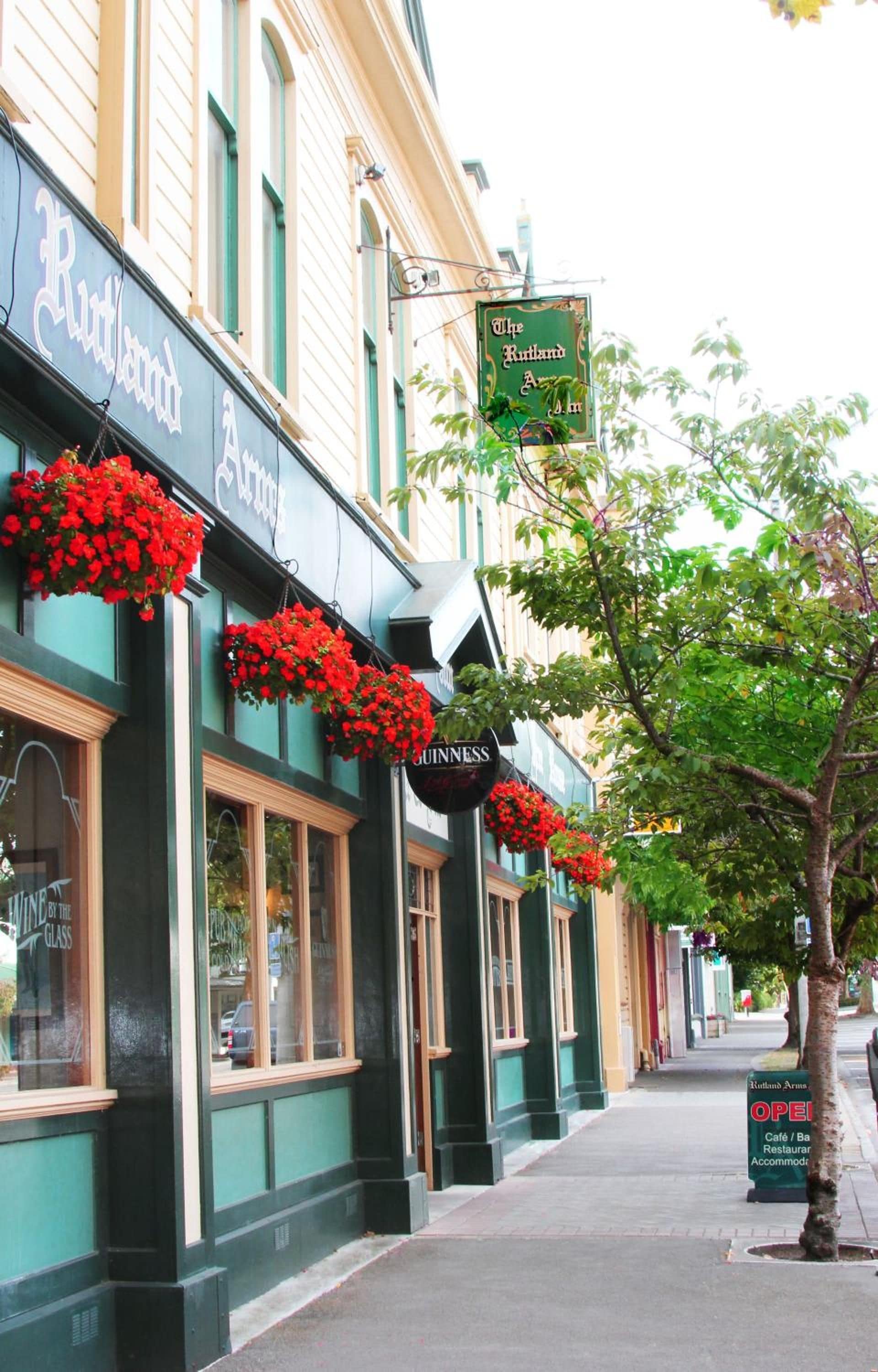 A building with hanging flower baskets and a sign for 'The Rutland Arms.'