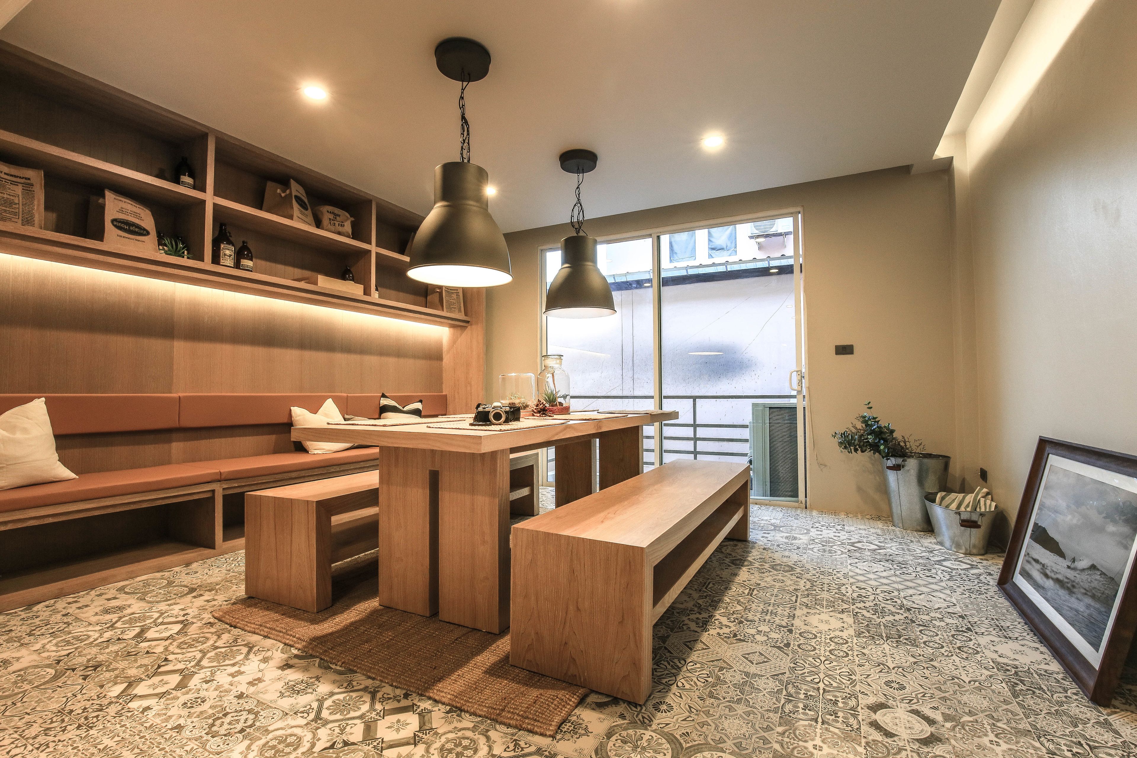 Et moderne køkken med træskabe, en central ø og hængende lamper.