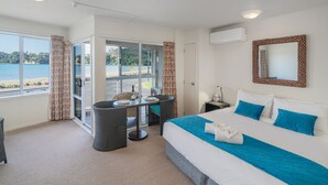 Habitación de hotel con cama, escritorio y vista a la playa.