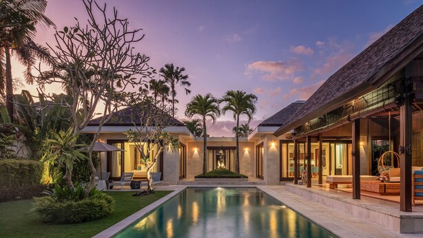 A modern villa with a swimming pool, outdoor seating, and a well-maintained garden.