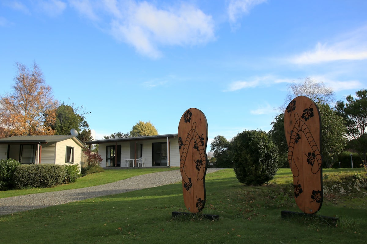 Un bâtiment avec une allée en gravier et une pelouse.