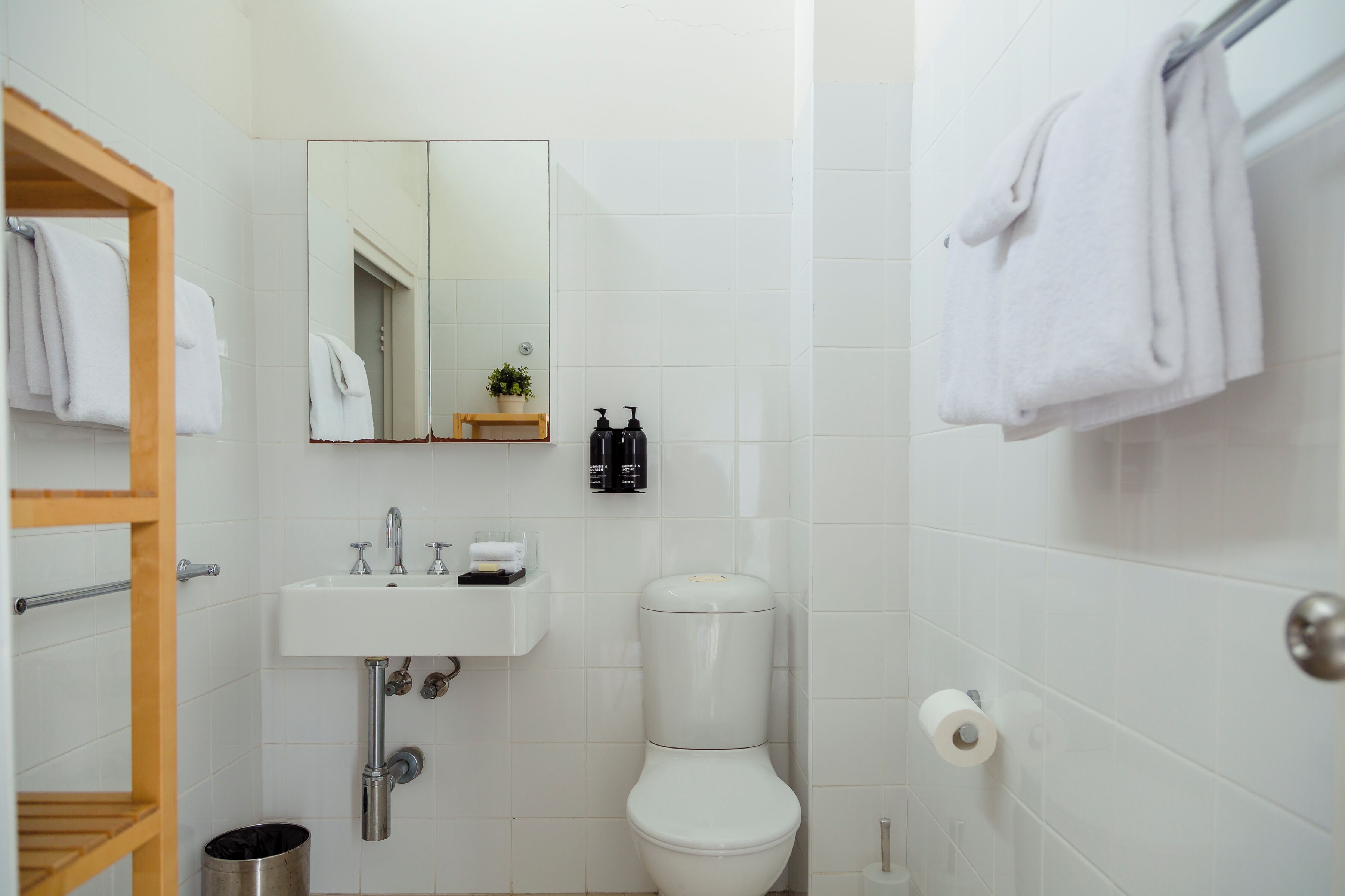 Ein Badezimmer mit einem weißen Waschbecken, einer Toilette und einem Handtuchhalter.