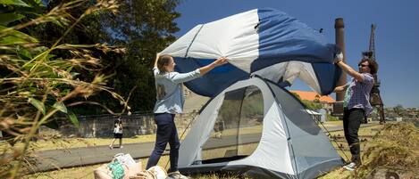 Two people setting up a tent outdoors.