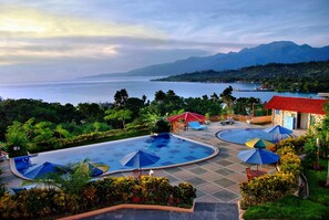 A resort with multiple swimming pools, outdoor seating, and a view of the sea and mountains. - Aston Niu Manokwari (Manokwari)