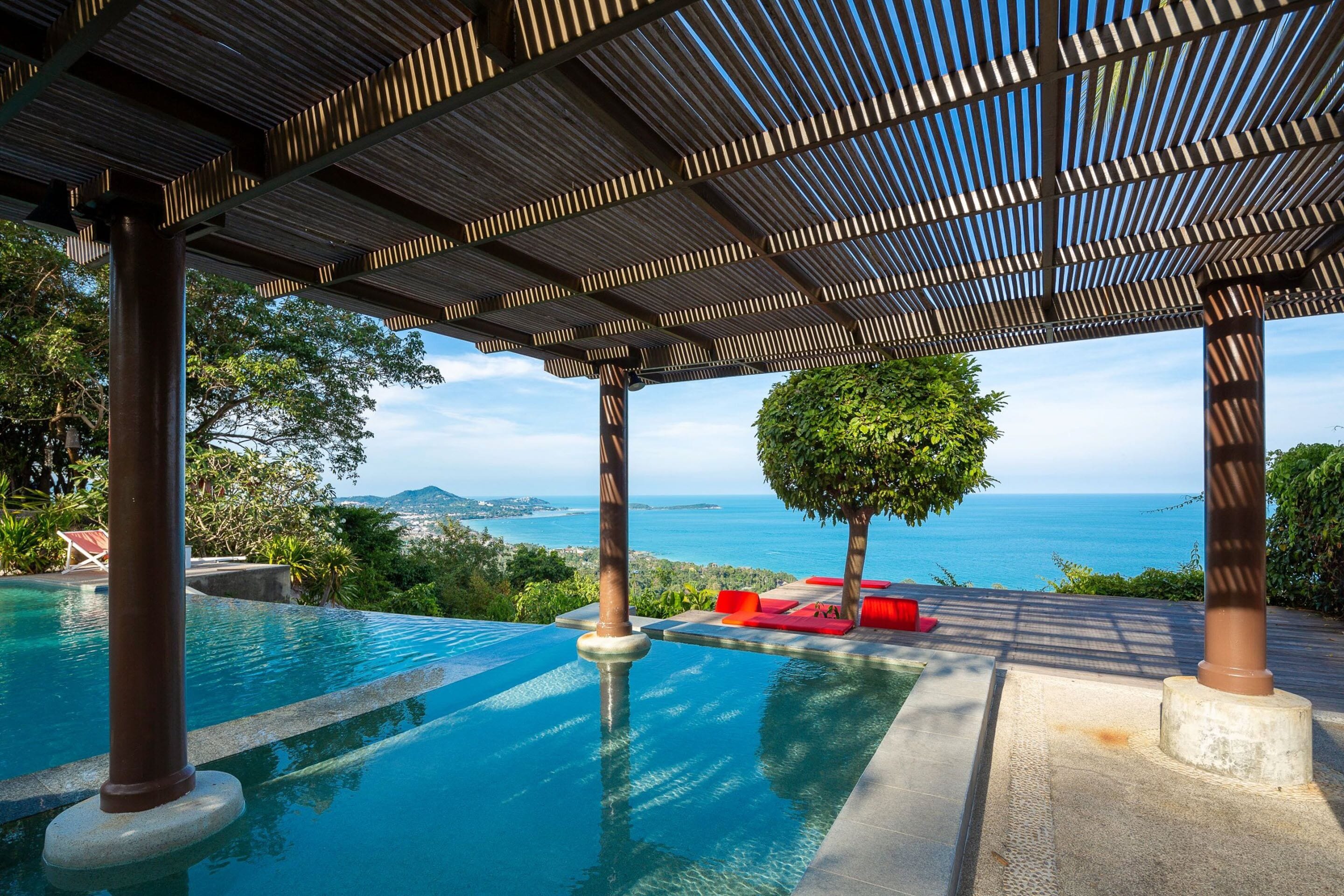 Una piscina al aire libre, sombrillas, sillones reclinables de piscina