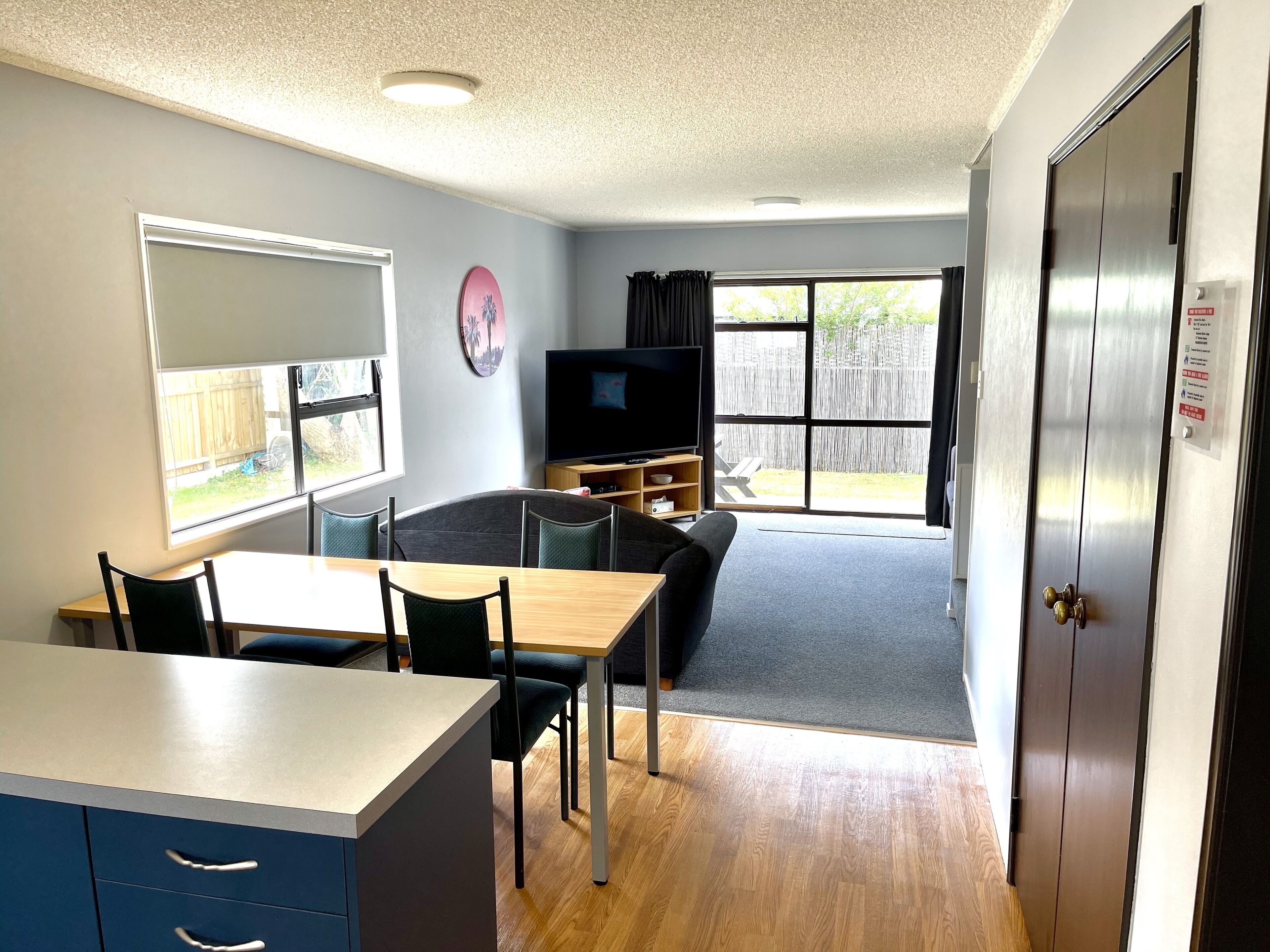 A compact living space with a kitchenette, dining area, and a TV.