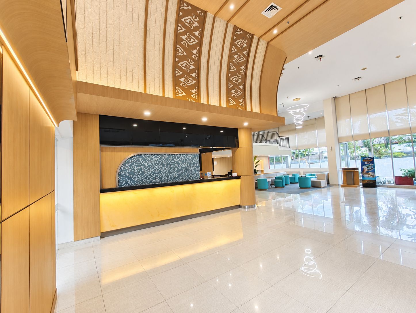 Un moderno vestíbulo de hotel con mostrador de recepción, zona de estar y amplias ventanas.