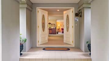 Un pasillo con dos puertas abiertas que dan a una habitación con una lámpara y un reloj.