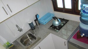 A kitchen with a sink, stove, and cabinets.