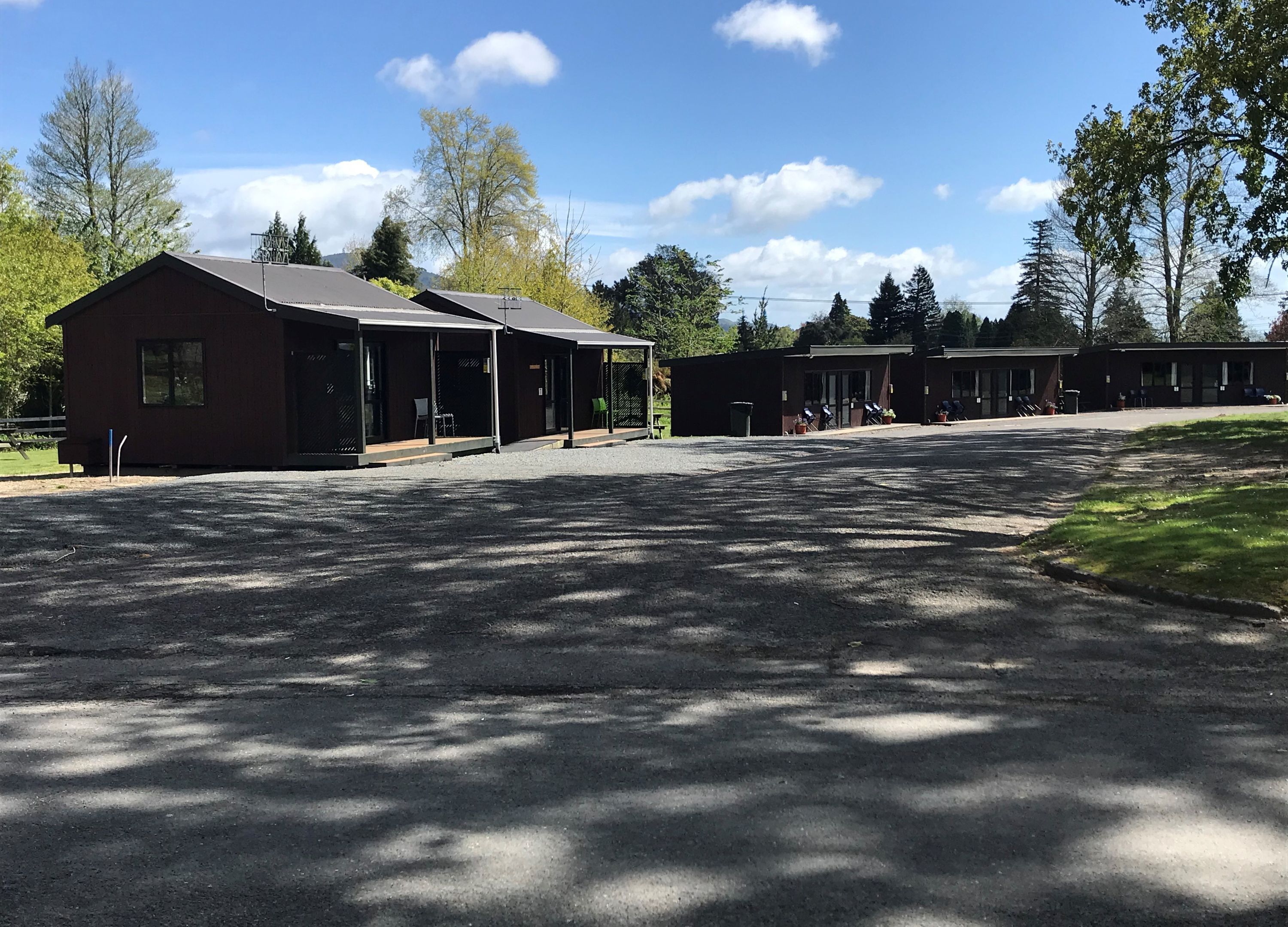 A building with a covered outdoor seating area and a parking lot.