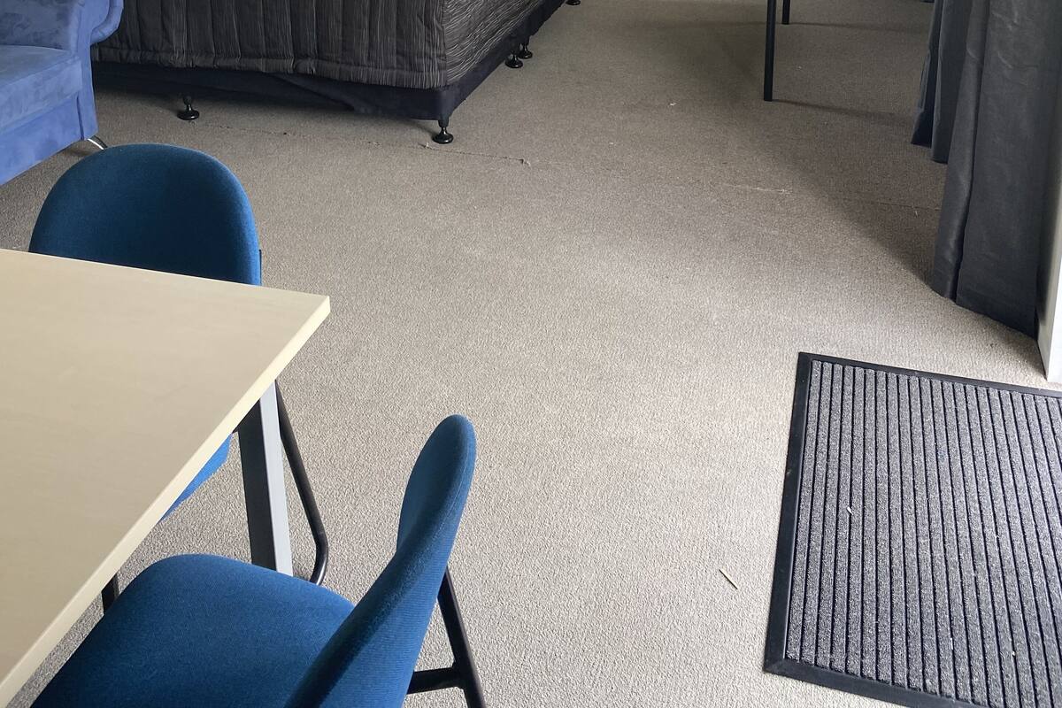 Une chambre de dortoir avec des lits superposés, un bureau et une chaise.