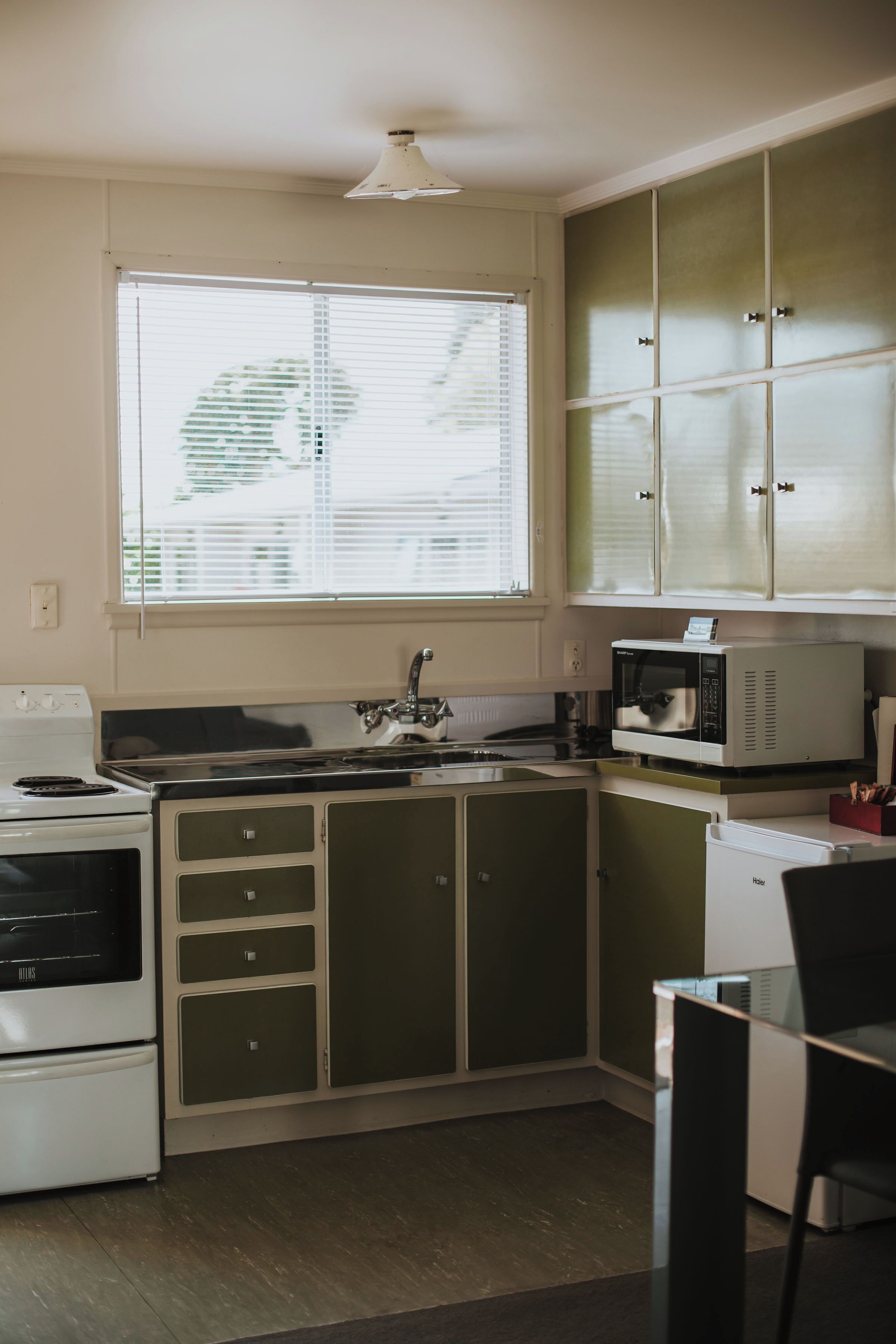 A compact kitchen with a stove, microwave, and cabinets.