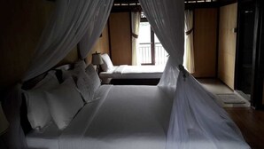 A room with a bed, curtains, a window, and a door. - Batur Lakeside Huts (Kintamani)