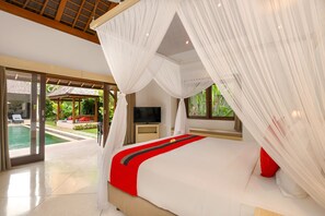Un dormitorio con cama, televisión y vista a una piscina.