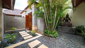 A courtyard with a water feature, stone steps, and a statue.