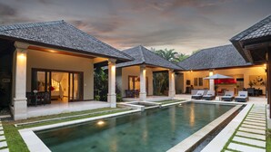 A poolside area with lounge chairs and a covered seating area.