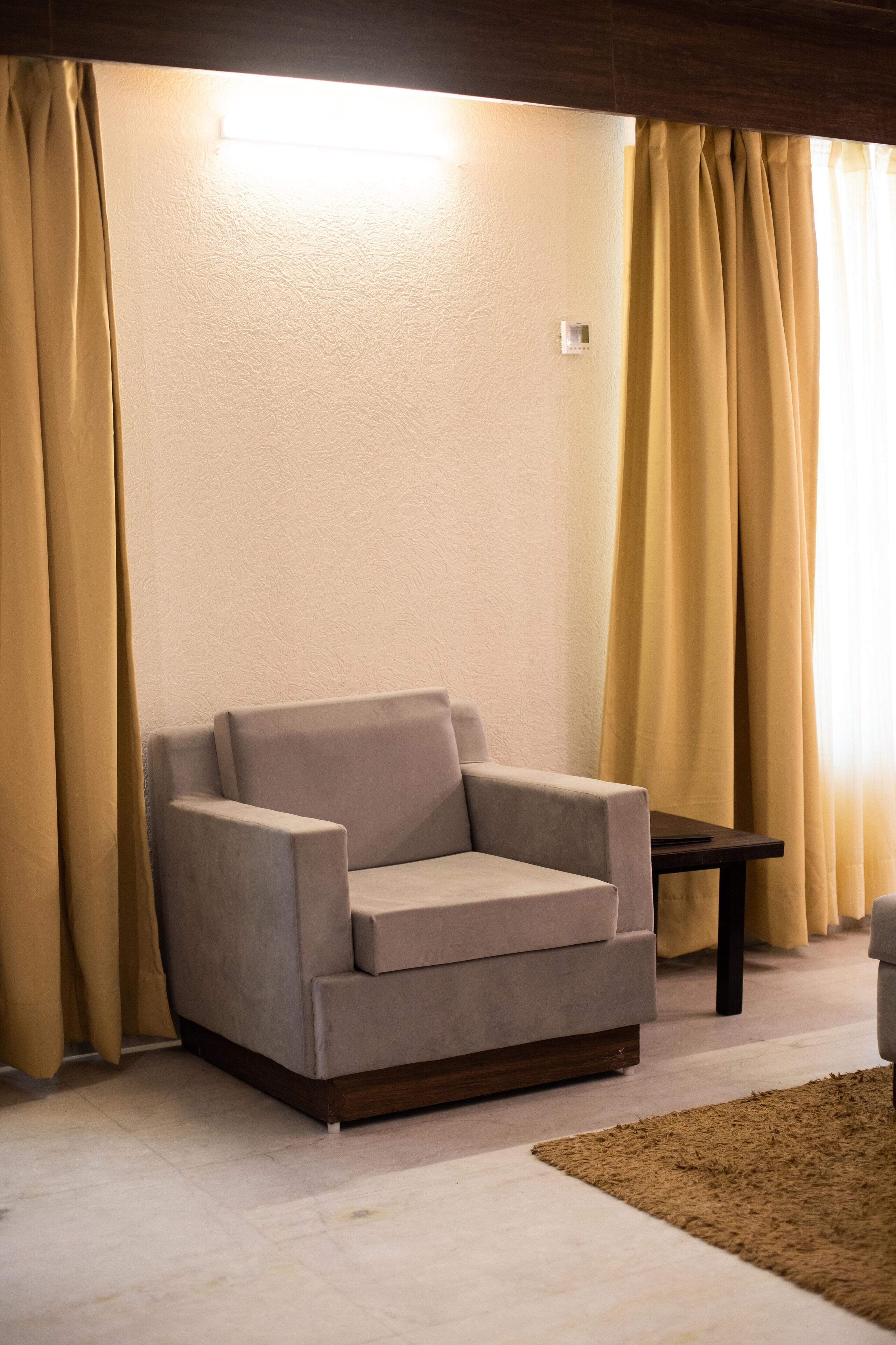 A living room with a beige sofa, a small table, and a brown rug.