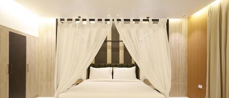 A bedroom with a bed, curtains, and wooden walls.