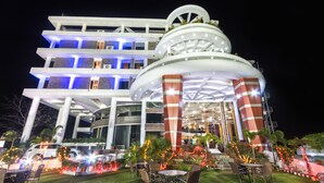 Un hotel de varios pisos con un atrio central, zona de estar al aire libre e iluminación decorativa.